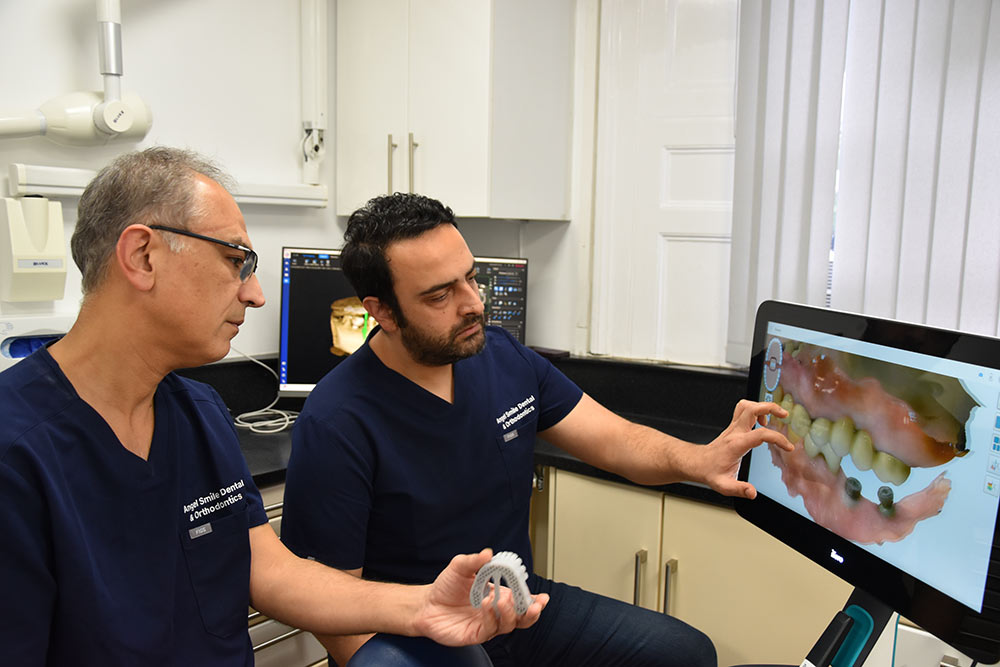 Dr Amin looking at dental implant images at Angel Smile